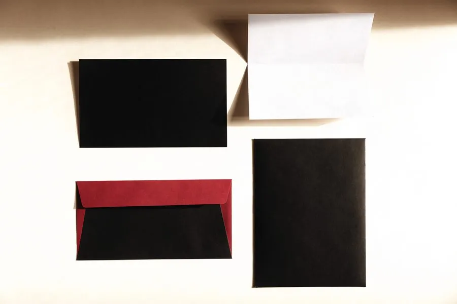 Geschäftsausstattung auf hellem Papier mit rot gefüttertem Umschlag